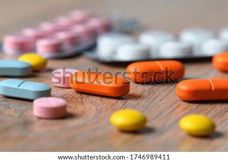 Assorted colored tablets and tablet packaging close-up on the table. Concept of protection and treatment of coronavirus infection.