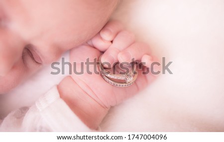 Baby hand. Closeup of newborn baby hand into parents hands. Family concept with the wedding rings in baby hand. Royalty-Free Stock Photo #1747004096
