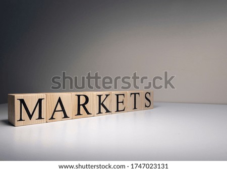 Markets text made with wooden blocks. It is illuminated by spotlight. Close up.