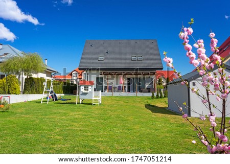 A modern single family house with a garden in summer scenery