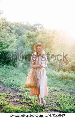 
a young girl in a long linen dress, a summer photo shoot, a girl in the forest, a hairstyle with a bow, a string bag with lemons, a girl with a bag and lemons