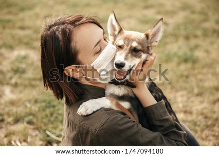 A young girl kisses a dog. Girl and dog on the street.
