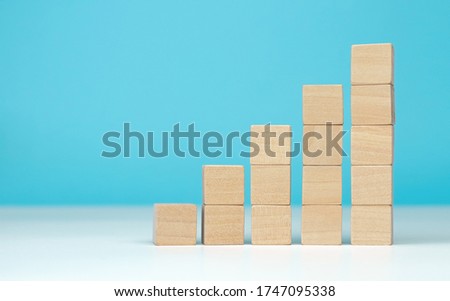 wooden blocks as a pyramid staircase on blue background. Success, growth, win, victory, development or top ranking concept
