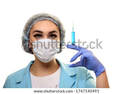 A girl in a medical mask, gloves and a robe on a white background. Beautician, beauty specialist. White-blue tones photo