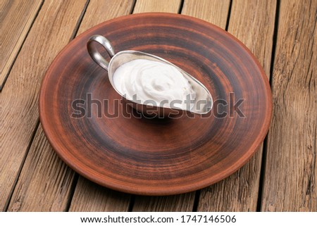 Sour cream in a sauceboat on wooden background Royalty-Free Stock Photo #1747146506