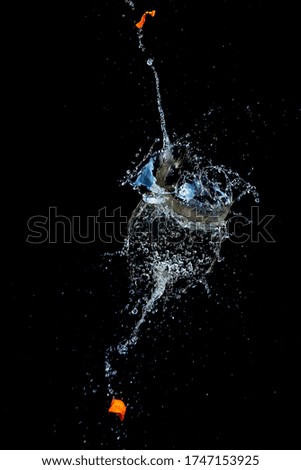 Artistic, abstract fruit splashes in water with black background
