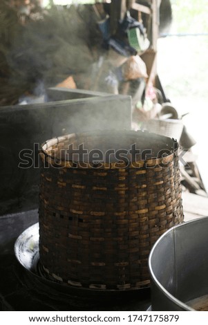 Thick smoke from the fire comes from a large wicker basket, Asia and Thailand