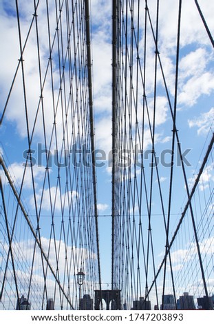 Unusual angle of view at famous Brooklyn Bridge on a sunny day with blue sky, NYC, USA. New York sightseeing and contemporary architecture lifestyle photo. Nobody. 