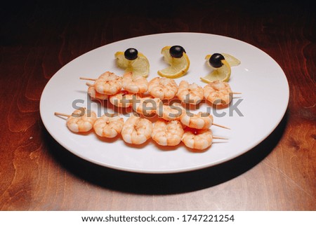 Stock Photo - Fried shrimps on white plate. Exotic delicacy
