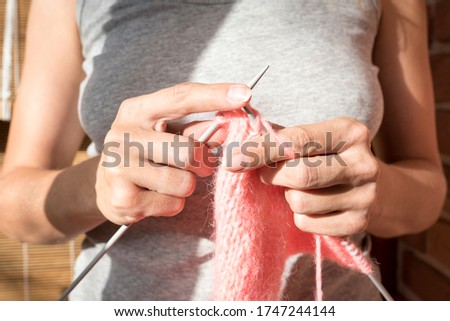 women's hands with knitting needles close up