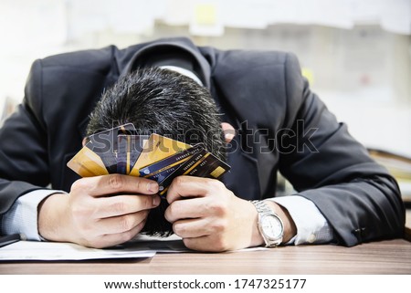 Businessman holding credit cards thinking seriously about payment loan problem - people with personal financial crisis concept  Royalty-Free Stock Photo #1747325177