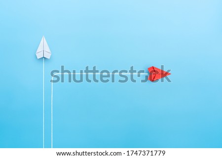 New normal concept with Red paper plane in new direction on blue background