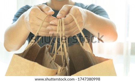 Women hand holding brown shopping bags or food delivery bags with copy space. Shopping online concept and delivery concept.