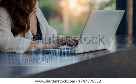 Hand of businesswoman using smart laptop computer, Digital marketing media and virtual globe shape diagram, Business Financial icons graphs, Work from home. Blurred image background. Double exposure.