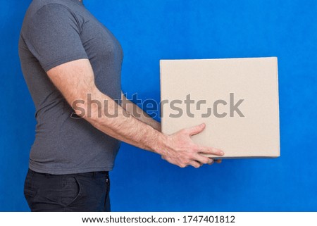 The box is in the hands of the man of the supplier who delivers the parcel.