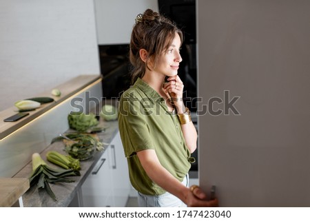 Young woman looking into the fridge, feeling hungry at night Royalty-Free Stock Photo #1747423040