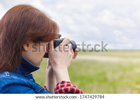 A woman takes pictures on a blurred background.