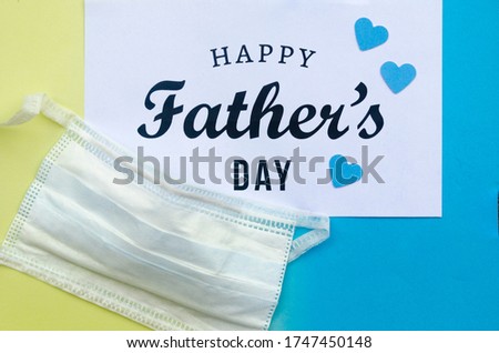 Greeting card Happy Father's day and protective face mask decorated with a black moustache. Concept of Father’s day in the context of coronavirus pandemic.