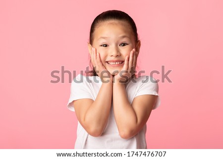 Wow. Closeup portrait of excited asian child touching her cheeks, isolated over pastel purple studio wall, copyspace