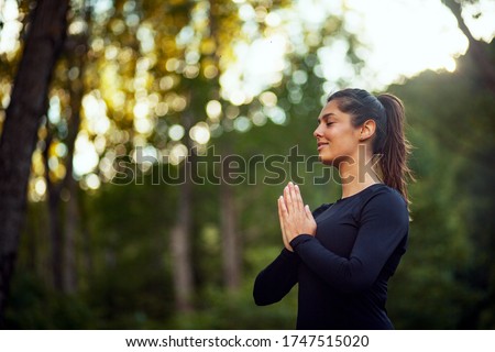 Young woman practicing yoga in a park Royalty-Free Stock Photo #1747515020