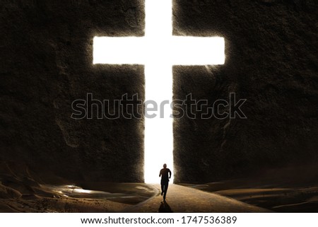 Person running to the safety of the Cross cut into a giant mountain Royalty-Free Stock Photo #1747536389