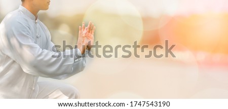 Young man practicing traditional Tai Chi Chuan, Tai Ji and Qi gong in the park for healthy, traditional chinese martial arts concept. Royalty-Free Stock Photo #1747543190