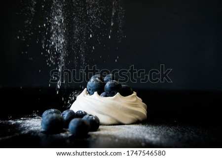 Blueberries and meringue dusted with icing sugar 