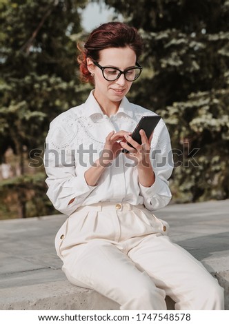 Stylish woman with mobile phone and coffee. Business woman outdoors.