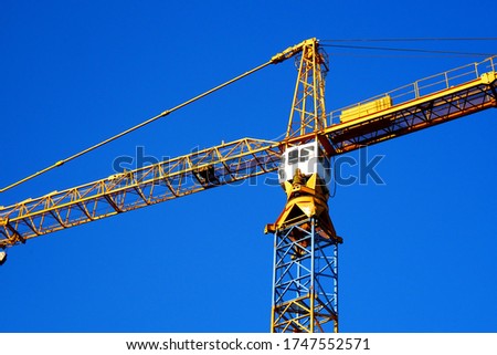 Crane. Self-erection crane against blue sky. Construction site.