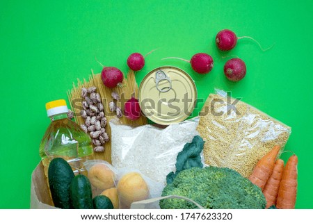 Donation. Food supplies crisis food stock for quarantine isolation period on green background. Rice, peas, cereals, canned food, oil, vegetables. Food delivery, coronavirus.