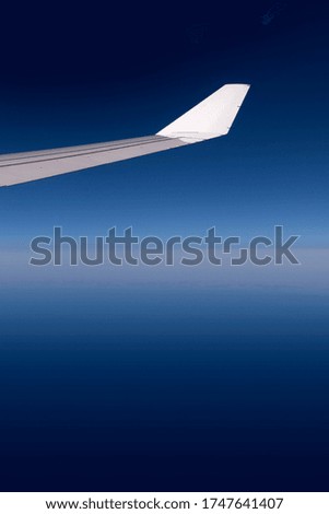 Wing of airplane, space and the sea in the background