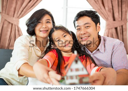 Asian family people happiness holding house model for plan to investment real estate in sleeping room.