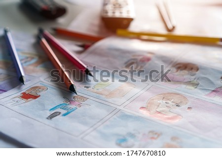 Color pencils on Document for Designer creative drawing in storyboard for film movie, Video Pre-production process in display script. Design shot scene layout template on desk studio. Media product