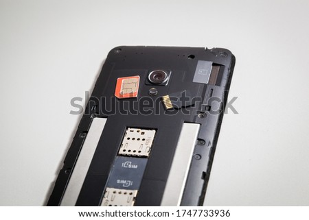 Smartphone with an open back cover, SIM card and memory card. The smartphone is under repair.
