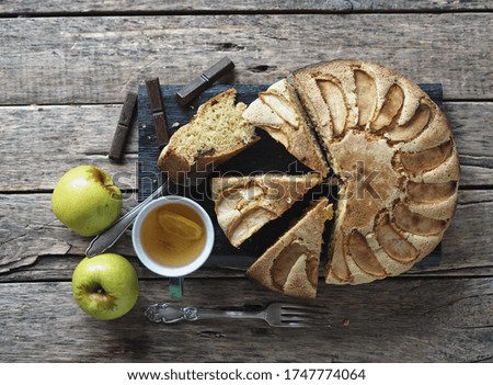Round homemade Apple pie on a rustic wooden background. The view from the top.Dessert of dough with apples and chocolate for any holiday.