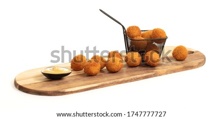 Dutch traditional snack bitterbal on a serving board, isolated Royalty-Free Stock Photo #1747777727