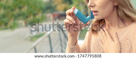 Closeup view of woman using asthma inhaler outdoors, space for text. Banner design Royalty-Free Stock Photo #1747795808