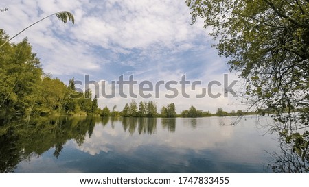 Woodland surrounding a bavarian lake under nice sky