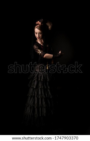 pretty young flamenco dancer dancing in dress isolated on black 
