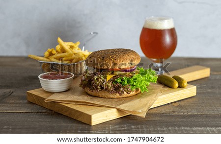 Homemade hamburger with craft beer, pickles, and french fries. Craft concept, copy space