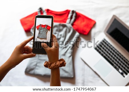Woman taking a photo of an article of clothing to sell online. Concept of selling clothes online. Second-hand clothes. Royalty-Free Stock Photo #1747954067