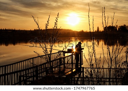 
Lone fisherman on the pier of Lake Komaysk