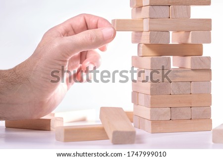 Close-up of  man's hand playing wood blocks stack game
