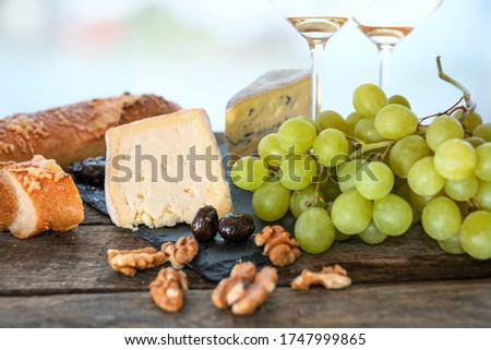 Cheese dekoration on rustic wooden table. Food photography with short depth of field and space for text for gastronomy concepts. Close-up.