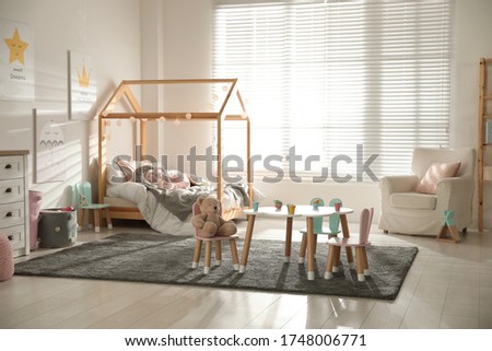 Small table and chairs with bunny ears in children's bedroom interior