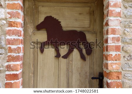 a Door with a Metal plate in form a Icelandic Horse