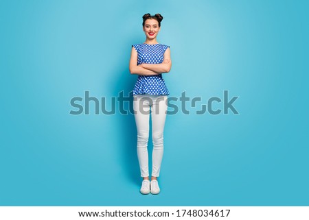 Full length photo of pretty lady good mood arms crossed enjoy warm weather sunny day summer spring wear dotted blouse white pants footwear isolated blue color background