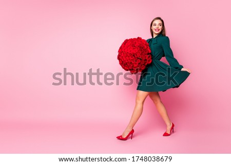 Full size profile photo of charming fancy lady carry large one hundred roses bunch walk from date cheerful wear short green dress high-heels isolated pastel pink color background