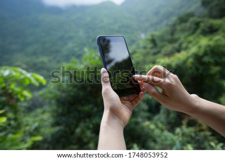 Hands using mobile phone taking picture in spring nature