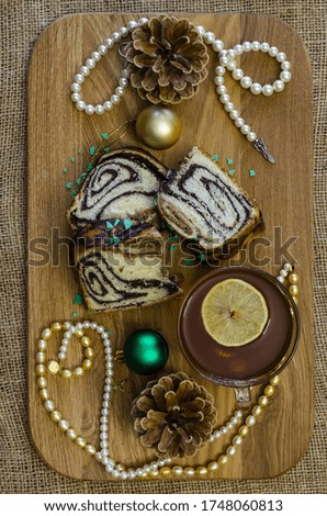 Christmas pastries with poppy seeds sprinkled with colored pieces of green chocolate on a wooden tray and burlap background
